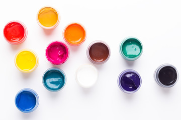 Multicolored gouache on a white background Isolated Paints in containers Top view Copy space