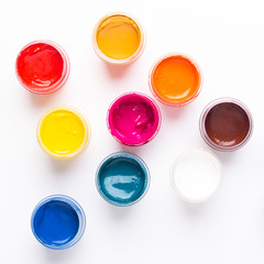 Multicolored gouache on a white background Isolated Paints in containers Top view Copy space