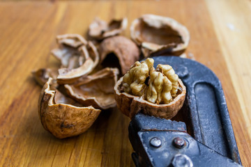 Fresh walnuts on a wooden table with nutcracker.