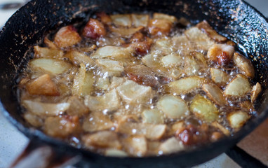 Cooking in a pan. Fat, meat,  and onions are fried in the frying pan_