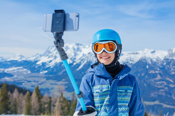 Fototapeta na wymiar Portrait of Girl snowboarder making selfie in the winter ski resort.