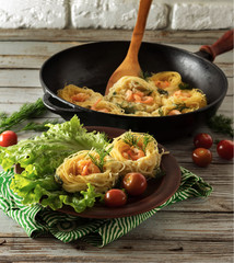 pasta with shrimps in the form of nests. A portion of pasta on a plate with lettuce. Near pan with pasta, tomatoes and dill