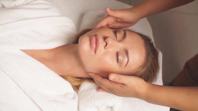 Gorgeous woman enjoys spa treatment in clinic. Girl takes care of her face