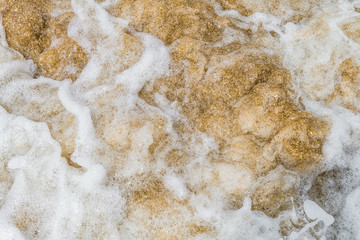 Raging sea surf close-up. Abstract background. Sea foam on the sandy shore.