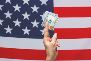 American dollars in the hand on the national flag background
