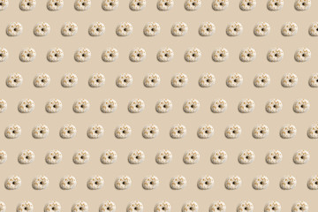 Sweet and tasty donuts with colorful icing and powder, like a pattern on a bright pastel color background. Homemade dessert and baking concept.