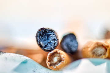 Macro image of cigarette butts with filters full of nicotine