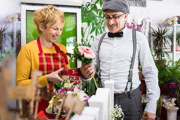Husband buying flowers and gifts for Valentine's day for his wife in local flower shop