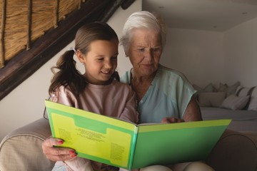 Grandmother and granddaughter reading story book