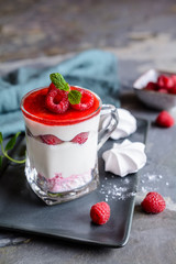 Layered dessert with crushed meringue kisses, curd, raspberries and whipped cream