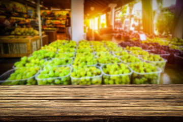 Wooden table on the street market among fresh vegetables and fruits   