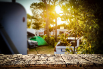 A campsite in a sunny place with a wooden board for an advertising product   