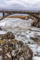 Brücke über Eisblöcken im Fluss im Winter in Island
