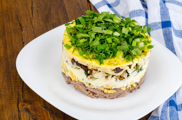 Layered portion salad with meat, cucumber, egg and mayonnaise