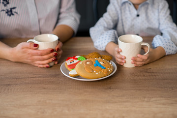 Mother and son in the kitchen with pastries. Studio shot, home interior.