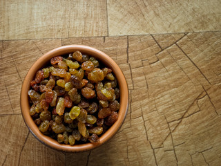 Fototapeta premium Raisins, in a brown clay plate on the table.