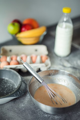 Up down shot of pancakes in the kitchen, home with flowers, eggs, fruits on the table.