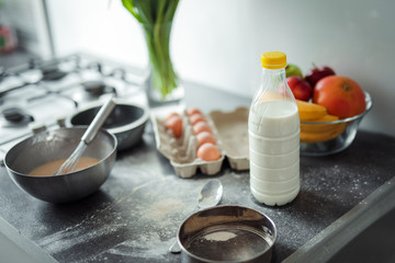 Up down shot of pancakes in the kitchen, home with flowers, eggs, fruits on the table.