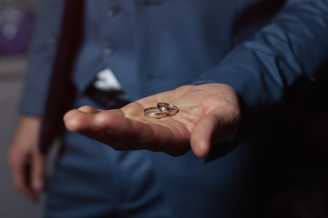 Wedding engagement rings on the palm of the groom.