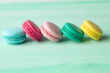 Sweet and colourful french macaroons on mint background 