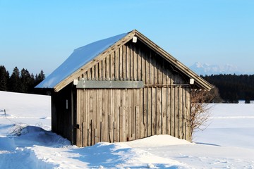 Holzhütte in Winterlandschaft im Alpenvorland, Allgäu, Bayern