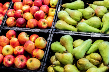 Grocery supermarket store. Shelves with variety of different orgnaic fresh ripe pears and apples. Vegetable and fruit market