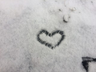 Heart shape drown in the fresh white snow. Background for Valentines 