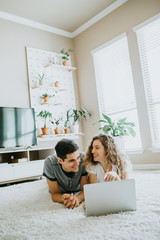 Happy Couple using Laptop at Home