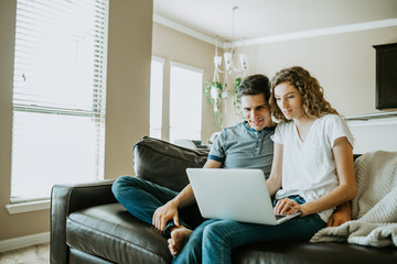 Happy Couple using Laptop at Home