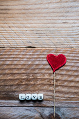 Lettres Love en bois et coeur rouge, arrière plan bois