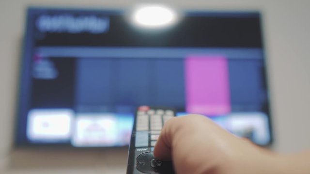 Smart tv with apps lifestyle and hand. Male hand holding the remote control turn off smart tv lifestyle . man hand controls TV holding remote. concept internet online cinema