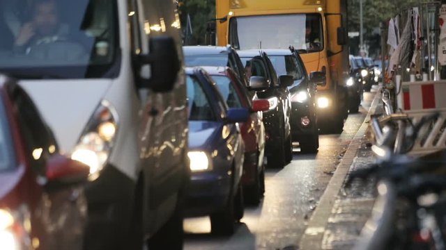 Traffic jams in modern city in the evening. Cars are stuck in slow moving traffic on the road of Berlin, Germany. Front view.