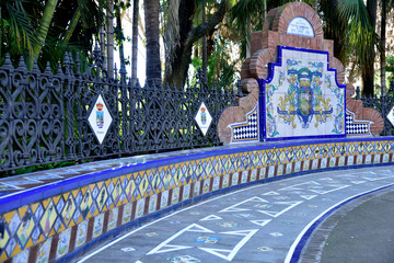 Malaga, Spain. Decorated bench - fence in the park. - obrazy, fototapety, plakaty