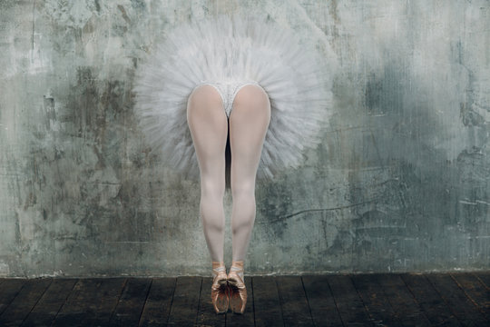 Ballerina legs. Beautiful woman ballet dancer, dressed pointe shoes and white round tutu.in ballroom.