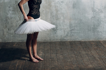 Ballerina putting on white tutu. Young beautiful woman ballet dancer,