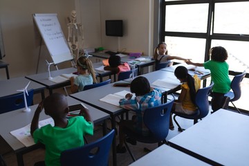 Fototapeta na wymiar Schoolkids studying at desk in classroom