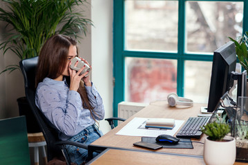Obraz premium Office worker taking a coffee break with a cup of espresso in her hands.