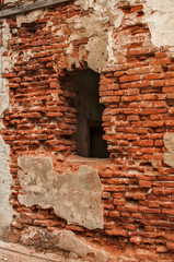 Broken window frame of ruined damaged abandon neglected country house brick wall with ruined stucco...