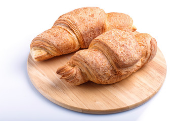 two croissants on wooden kitchen board isolated on white background