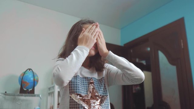 hide and seek. little girl covered her eyes face with her hands peek a boo waiting for a surprise. slow lifestyle motion video. teen girl playing bo-peep. childhood concept game hy - spy