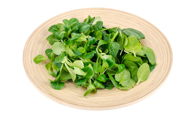 Mix of corn salad and spinach leaves on wooden plate