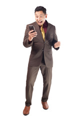 Attractive young businessman receive good news on his phone, happy winning gesture