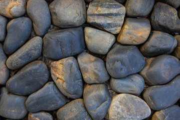 Round stone paving. Natural stone masonry top view. Seaside pebble photo texture. Stone wall surface.