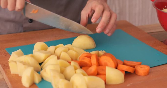 Peeled potato being chopped using sharp knife, close up
