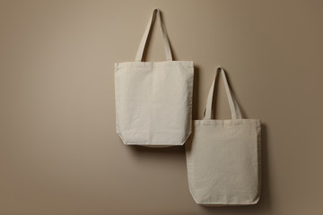 Eco tote bags hanging on color wall. Space for design