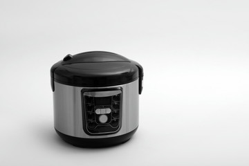 Modern electric multi cooker on light background. Space for text