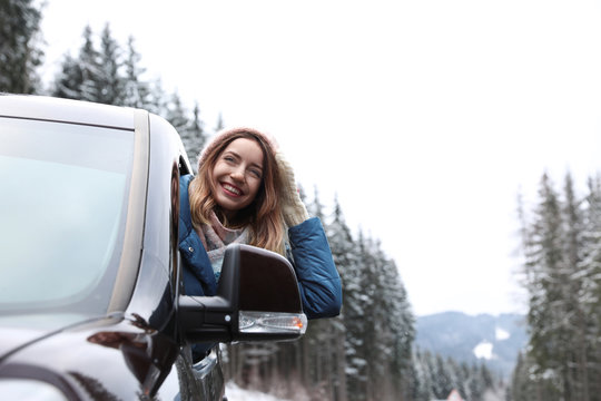 Young Woman Driving Car And Looking Out Of Window On Road. Winter Vacation