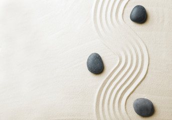 Zen garden stones on sand with pattern, top view. Space for text