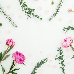 Floral frame composition with pink peonies and eucalyptus branches on white background. Flat lay, top view