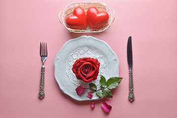 Red rose on white dish, with fork and knife, And couple heart in white basket, On pink background, Concept of Valentine's Day, Romance, Love, dinner, Special day